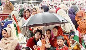 A family huddles under an umbrella at Sirhind where the inclement weather forced Congress president Sonia Gandhi to cancel her rally on Saturday