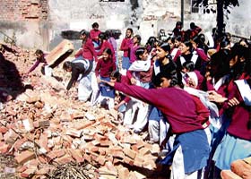 Schoolchildren remove a wall of kutcha bricks built to block a passage to Government Senior Secondary School, Pathankot