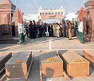Pakistani officials and Pakistan Rangers wait for the coffins to be handed over to them at the Wagah border on Saturday. 