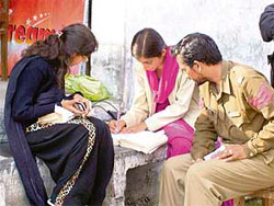 A policeman looks on as helpers of students indulge in mass coying at an examination centre in Sujanpur 