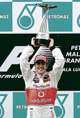 McLaren�s Formula One driver Fernando Alonso of Spain lifts the trophy after winning the Malaysian Grand Prix in Sepang.