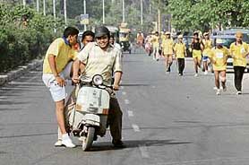 Two runners hitch a ride during the marathon in Jalandhar on Sunday.