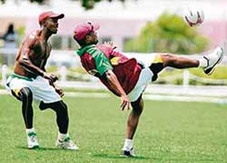 West Indies' captain Brian Lara (right) kicks a ball as team-mate Devon Smith looks on 