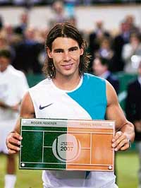 Rafael Nadal holds the trophy after beating Roger Federer in the �Battle of the Surfaces� tennis match played on a special court � half clay, half grass � in Mallorca, Spain, on Wednesday. Nadal won 7-5, 4-6, 7-6. 