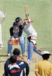 RARING TO GO: Virender Sehwag plays a shot as wicketkeeper Mahendra Singh Dhoni watches on the last day of a five-day conditioning camp at Eden Gardens in Kolkata on Sunday
