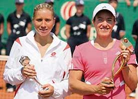 Justine Henin of Belgium (right) and Alona Bondarenko of Ukraine hold their trophies after the final of the J&S Cup tennis tournament in Warsaw on Monday. Henin became the first player to win three titles this season when she eased to a 6-1, 6-3 victory over unseeded Bondarenko in the weather-delayed final.