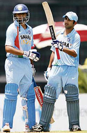 Gautam Gambhir raises his bat after completing his century as captain Rahul Dravid looks on during the second one-dayer against Bangladesh in Dhaka on Saturday.