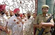 Security personnel stand in front of the main gate of Naam Charcha Ghar at Dera Sacha Sauda in Patiala