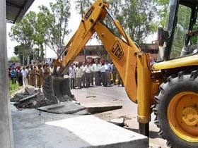 A JCB removes encroachments on the Saili road in Pathankot