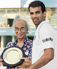 Zaheer Khan poses with the man-of-the-match award as a Bangladesh Cricket Board official looks on during the awards ceremony of the Test series between India and Bangladesh at the Sher-e-Bangla National Cricket Stadium at Mirpur in Dhaka, on Sunday.