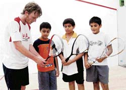 Former world number one squash player Peter Nicol giving tips to children at the World Squash Academy in Mumbai on Tuesday.