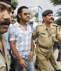 Mahendra Singh Dhoni being escorted by policemen at the Birsa Munda Airport on his arrival in Ranchi