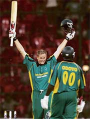 Africa XI�s Shaun Pollock celebrates his century as team-mate Thomas Odoyo looks on during the first one-day international against Asia XI at the Chinnaswamy stadium in Bangalore on Wednesday. 