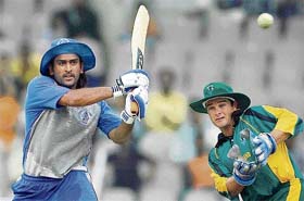 Asia XI�s Mahendra Singh Dhoni plays a shot as Africa XI�s Mark Boucher looks on during the third match of the Afro-Asia Cup at the M.A.Chidambaram in Chennai