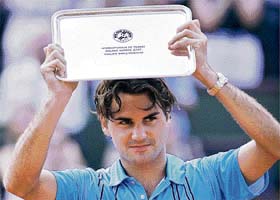 Roger Federer holds up his trophy at Roland Garros in Paris