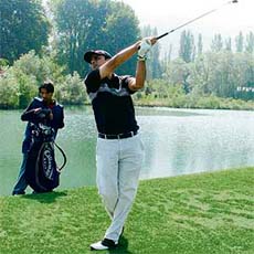 A golfer plays a shot during the GK invitational golf tournament at the Royal Springs golf course in Srinagar