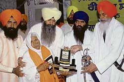 Balwant Singh Nandgarh, jathedar, Takht Damdama Sahib, and Harnam Singh Khalsa, chief of Damdama Sahib, honour a woman, whose kin was killed during Operation Bluestar, at Guru Teg Bahadur Nagar Gurdwara in Jalandhar on Monday. 