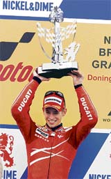 Australia�s Casey Stoner holds his trophy as he celebrates winning the 500cc British Moto Grand Prix at Donington Park on Sunday. Stoner extended his overall world championship lead after claiming his fifth victory of the season.