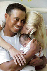In this undated photo released by WireImage, golfer Tiger Woods holds his newborn daughter Sam Alexis Woods as wife Elin kisses the baby on the head. Sam Alexis, the first child for Woods and his wife, was born on June 18 in Orlando, Florida. 