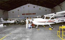 Staff members work on a trainer aircraft at the Karnal Civil Aviation Club.