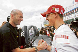 French football star Zinedine Zidane (left) shakes hands with German Formula One champion Michael Schumacher after the third free practice session of the French Grand Prix at the Magny Cours circuit on Saturday.