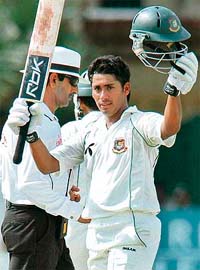 Bangladesh captain Mohammad Ashraful raises his bat after reaching his century during the third day of the second Test against Sri Lanka in Colombo