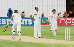 Zaheer Khan looks on as Joe Denly (right) and Owais Shah of England Lions take a run on the first day of the three-match match at the Ford County Ground in Chelmsford