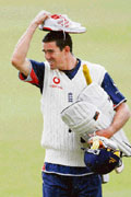 England's Kevin Pietersen with shoes over his head walks in the rain to a net practice session at Lord's, London, on Tuesday.