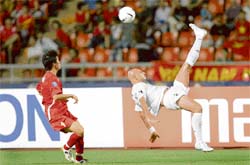 Iraqi defender Jassim Mohammed Gholam (R) executes a bicycle kick as Vietnamese player Le Cong Vinh looks on during the Asian Football Cup's quarter final at the Ratchamangla Stadium in Bangkok