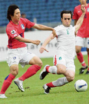 South Korea's Kim Chi-woo (L) and Iran�s Ali Karimi vie for the ball during the Asian Cup quarterfinals in Kuala Lumpur on Sunday.