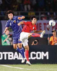 South Korea�s Oh Beom-seok (right) and Japan�s Satoru Yamagishi fight for the ball during the bronze-medal match of the Asian Cup football tournament at the Jaka Baring stadium in Palembang, Indonesia