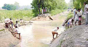 Workers trying to plug a 95-foot breach in the Daulatpura sub-canal in Abohar on Monday.