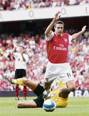 Arsenal�s Robin van Persie gets past Fulham�s Moritz Volz during their English Premier League soccer match at the Emirates Stadium in London on Sunday. Arsenal won 2-1