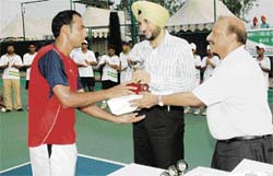 Pakistan�s Aqeel Khan receives the trophy from G.S. Bhullar (centre), SSP, Ludhiana (Rural), after winning the ITF Futures tennis title at Jassowal village, near Mandi Ahmedgarh, on Saturday.