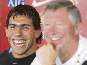 Manchester United's new signing Carlos Tevez (L) laughs with manager Sir Alex Ferguson during a news conference at the club's Carrington training complex in Manchester. 