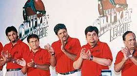 Former Indian captain and Chairman of ICL Kapil Dev (C) and other board members applaud during a press conference in Mumbai on Monday.