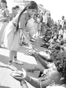 Students from Ryan International School distribute food to homeless people in Patiala, on Wednesday.