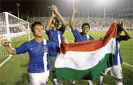 Baichung Bhutia (L) holds the national flag as he celebrates with his teammates after victory over Syria in the final.