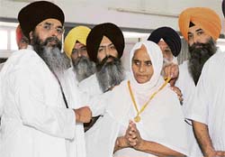 Bhai Mohkam Singh, convener of the Khalsa Action Committee, honours the mother of Dilawar Singh in Amritsar