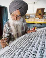 Gurmeet Singh (70) works on a handwritten version of Guru Granth Sahib at his home in Amritsar