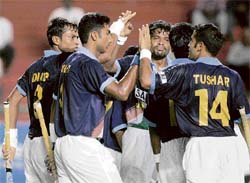 Dilip Tirkey (left) celebrates with team-mates after scoring a goal during the Pool B match against China. � AFP