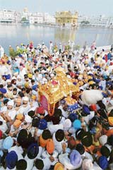 Head granthi of the Golden Temple Gurbachan Singh carries Guru Granth Sahib as devotees carry the Palki Sahib while taking part in a procession from Gurdwara Ransar to Akal Takht