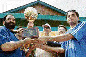 Chief Minister Ghulam Nabi Azad presents trophy to the captain of Jammu and Kashmir Bank after it defeated state Police in the final of Police Martyrs Memorial Football Tournament in Srinagar on Sunday.
