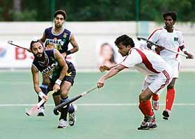 Rajpal Singh (left) pushes the ball as Bangladeshi players run to challenge him during their Asia Cup hockey match in Chennai