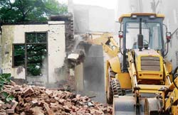 Bulldozers being used to pull down some shops and houses to make way for widening the entrance leading to the Jallianwala Bagh memorial