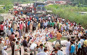 Residents of Tharial village block the Pathankot-Jammu highway at Madhopur village on Friday.