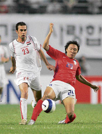 South Korea's Shin Young-Rok (R) fights for the ball with Syria's Aymana Habal (L) during their Olympics qualifier football match in Seoul on Wednesday.