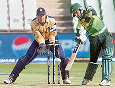 Pakistan's captain Shoaib Malik (R) plays a shot as Scotland's wicketkeeper Colin Smith watches during their ICC World Twenty20 cricket match against Scotland in Durban.