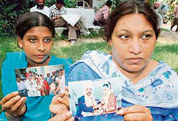 Madhvi (right) and Laxmi show the photographs of their marriage with Mahesh Kumar.