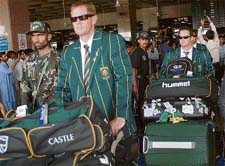 South African cricketers Shaun Pollock (L) and Mark Boucher push their luggage trolleys upon their arrival at Karachi International airport on Wednesday.